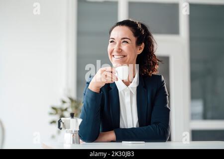 Felice donna d'affari che tiene la tazza del caffè Foto Stock