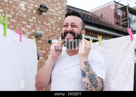 Uomo felice che indossa il vestito nel cortile posteriore Foto Stock