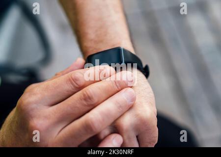 Uomo maturo che misura la frequenza cardiaca in un orologio intelligente Foto Stock