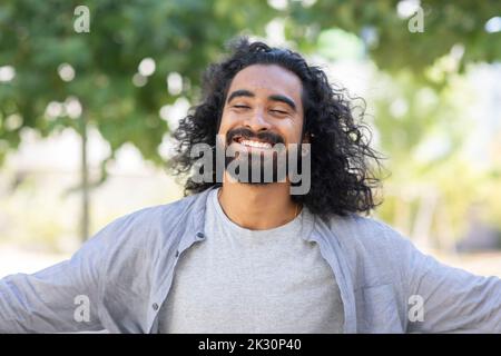 Felice giovane uomo bearded con capelli lunghi Foto Stock