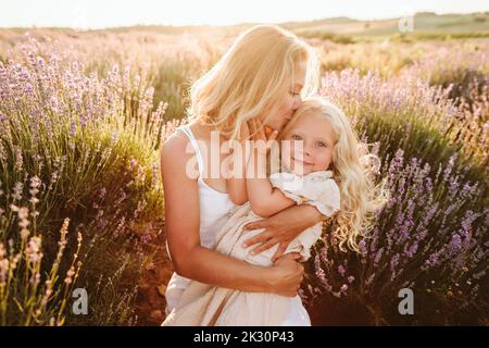 Madre bacia figlia in campo di lavanda Foto Stock