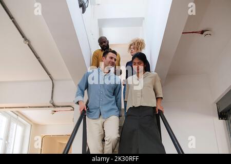 Gruppo di uomini d'affari che scendono le scale in un ufficio moderno Foto Stock