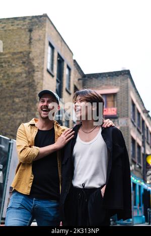 Felice coppia gay a piedi in città Foto Stock