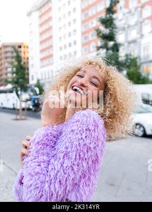 Felice giovane donna che ride sul sentiero in città Foto Stock