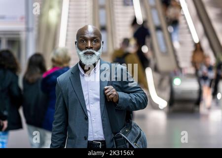 Uomo d'affari serio con borsa per il laptop alla stazione ferroviaria Foto Stock