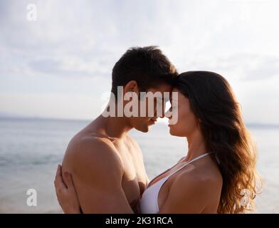 Non potevo pensare a un modo migliore per trascorrere la mia giornata. Una giovane coppia che condivide un momento romantico mentre si trova in spiaggia. Foto Stock