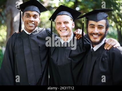 Sono stati diretti al successo. Ritratto di tre studenti maschi felici il giorno della laurea. Foto Stock