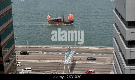 Autostrada sopraelevata e la famosa giunca turistica a vela rossa, Hong Kong, Cina. Foto Stock