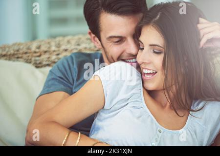 Ancora molto nella fase di luna di miele, una giovane coppia che si coccola a casa. Foto Stock