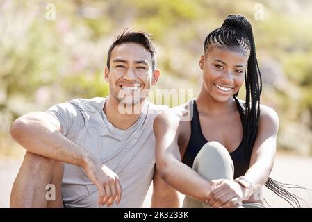 Fitness, ritratto e coppia felice e vario legame dopo la corsa di mattina, relax e riposo mentre si siede all'aperto. Donna sorridente godendo una sana Foto Stock