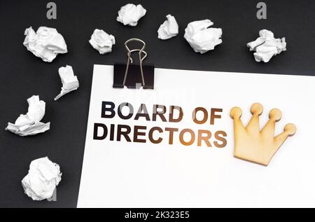 Concetto di business e finanza. Su sfondo nero, carta stropicciata e foglio con iscrizione - Consiglio di Amministrazione Foto Stock
