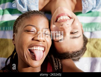 Picnic, estate e le amiche che si rilassano su una coperta all'aperto, folle lingua e divertirsi insieme. Donna nera, sorridere e felice lgbtq coppia posa Foto Stock