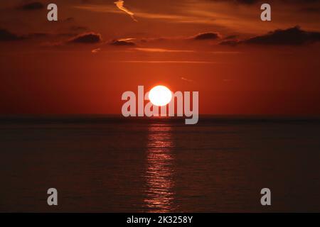 foto del sole che sorge sul mare di prima mattina Foto Stock
