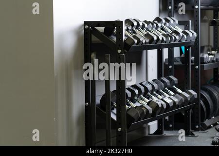 Dumbbell parete home palestra blurry set di stoccaggio strongman sport, per accessori per il nero da bodybuilder attivo, bodybuilding in forma. Sollevamento , Foto Stock