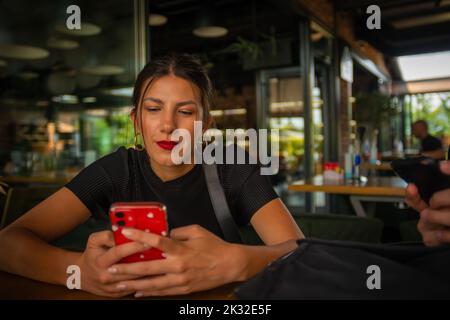 Una donna d'affari stupefacente appena ha rifinito con il suo lavoro ed ora sta chiacchierando sul suo telefono Foto Stock