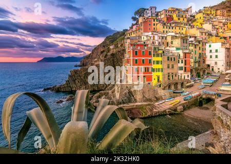 Vista panoramica del piccolo villaggio di Riomaggiore cinque Terre in Italia contro il suggestivo cielo al tramonto Foto Stock