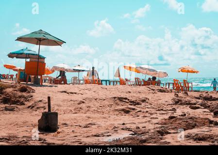 Il Sombrero sedie e la gente sulla spiaggia, Boca do Rio Beach a Salvador, capitale di Bahia, Brasile Foto Stock