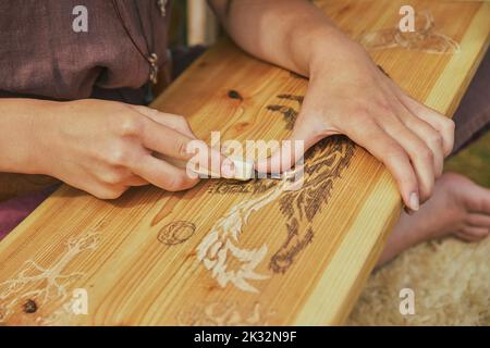 Hojbjerg, Danimarca, agosto 2022: Ragazza che intagliano il legno al festival vichingo Foto Stock
