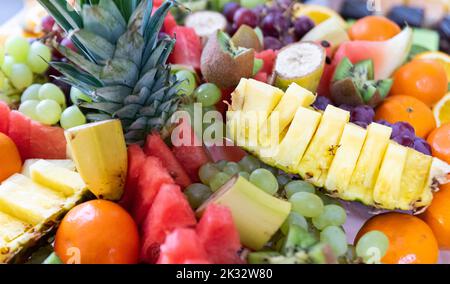 Agrumi tagliati a pezzetti. Vassoio con una varietà di agrumi colorati e gustosi. Foto Stock