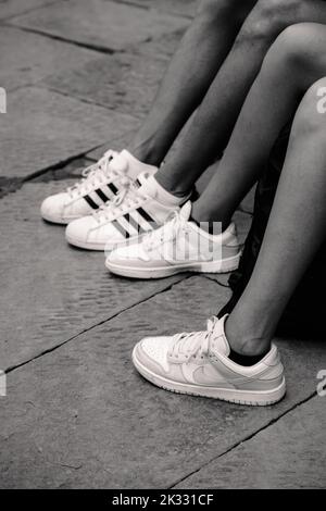Siena, Italia - Agosto 17 2022: Gambe e sneakers bianchi sulla strada Foto Stock