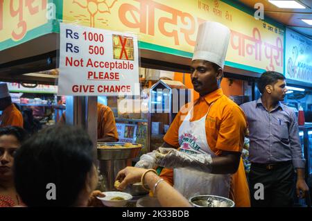 Un cuoco indiano che prepara cibo di strada alla stalla di Mumbai di notte Foto Stock