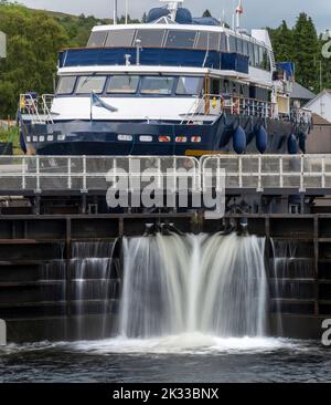 Inizio del canale di Caledonian, vicino a Fort William e ben Nevis, acqua che fuoriesce dalla porta di chiusura, con una piccola nave scozzese, in attesa che i livelli dell'acqua siano a casa Foto Stock