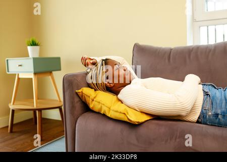 donna ispanica latina stanca prendere il pisolino sul divano durante il giorno Foto Stock