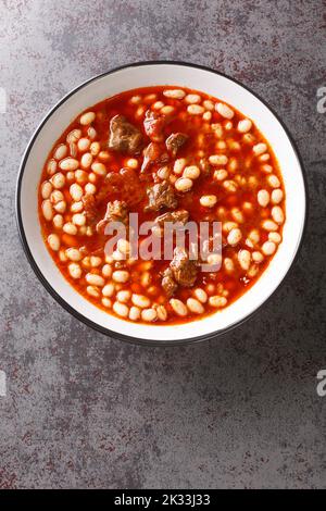 Turco Kuru Fasulye haricot fagiolo e carne tradizionale cibo closeup nel piatto sul tavolo. Vista verticale dall'alto Foto Stock