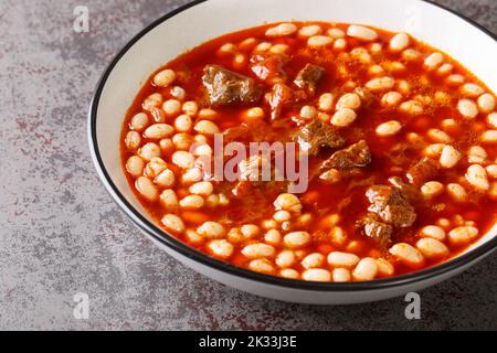 Stufate di Fasulye di Kuru piccante dai fagioli con l'agnello in salsa di pomodoro primo piano in una ciotola sul tavolo. Orizzontale Foto Stock