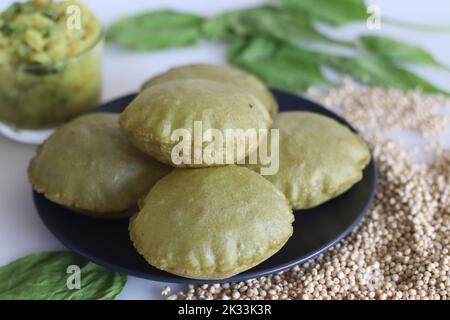 Jowar palak puri o spinaci sorgo fritti pane piatto. Pane fritto fatto di farina di miglio di sorgo e spinaci purei. Servito con purè di patate speziate gr Foto Stock