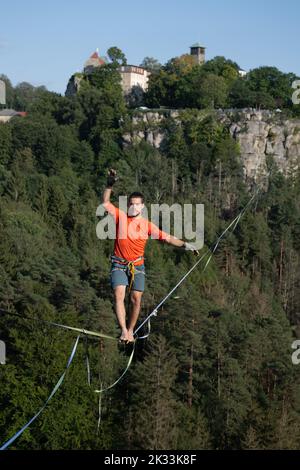 Hohenstein, Germania. 24th Set, 2022. Il corridore slackline Gregor Lawrenz corre alla Highline - e festa di famiglia su una corda lunga 360 metri tra il castello Hohnstein e l'Hockstein in 110 metri di altezza sul Polenztal. Credit: Sebastian Kahnert/dpa/Alamy Live News Foto Stock