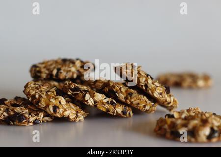 Spuntini salutari serali a base di avena arrotolata, plantane puree mature e uvetta. Girato su sfondo bianco con piantina matura e avena intorno Foto Stock