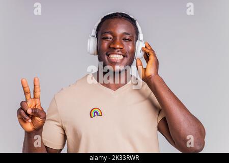 uomo messicano con cuffie bianche che ascolta musica in t-shirt beige Foto Stock