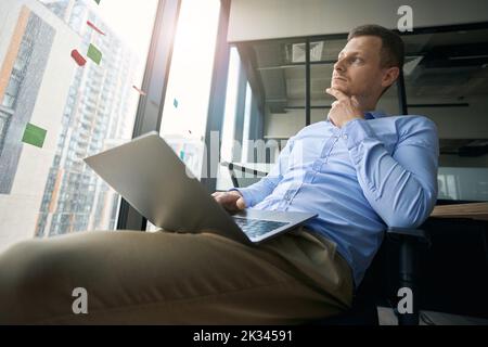 Dipendente aziendale penoso seduto nel suo posto di lavoro Foto Stock