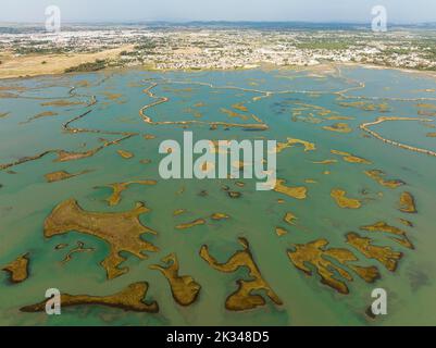 Rete di canali e ruscelli in bassa marea, nella palude della Bahia de Cadice, in lontananza la città di Chiclana de la Frontera, aerea Foto Stock