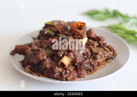 Arrosto di montone. Arrosto di montone piccante preparato in stile Kerala. Ripresa su sfondo bianco Foto Stock