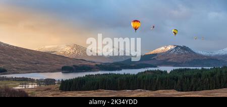 Immagine composita digitale di palloncini ad aria calda che volano sopra Epic Beautiful Inverno alba panorama paesaggio immagine di luce brillante sulla catena montuosa e. Foto Stock