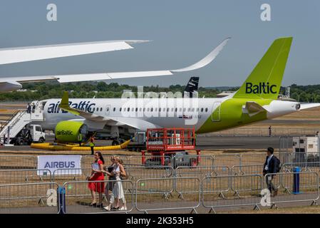 Fiera aerea internazionale di Farnborough 2022. Fiera aerospaziale, con Air Baltic Airbus A220 -300 Airliner jet plane in mostra da visitare. Visitatori femminili Foto Stock