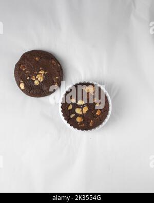 Vista dall'alto del biscotto a tre scaglie di cioccolato, piatto di biscotti al cioccolato fondente, biscotti al cioccolato su carta pergamena, biscotti al cioccolato in stile panetteria Foto Stock