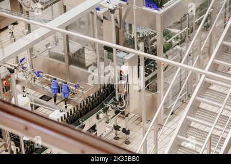 Imbottigliamento e sigillatura della linea di produzione di nastri trasportatori per vino in un'azienda vinicola moderna Foto Stock