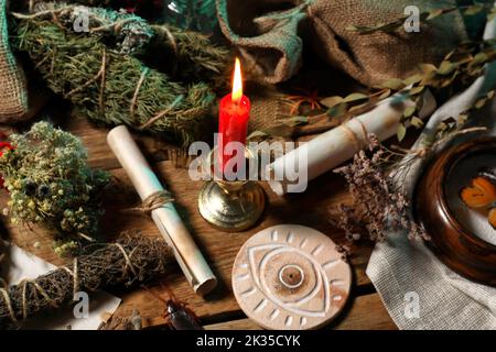 Attributi magici e antico rotolo su tavola di legno Foto Stock