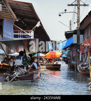 Ratchaburi, Thailandia 10 aprile 2022 - Damnoen Saduak mercato galleggiante venditori in Thailandia che vendono frutta, verdura e prodotti dalla loro barca. Foto Stock