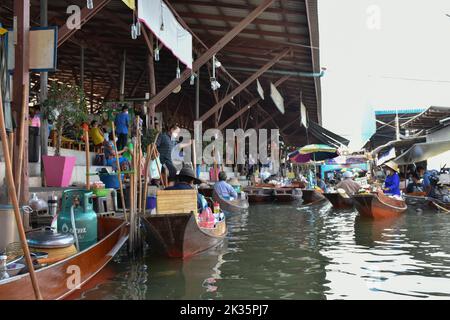 Ratchaburi, Thailandia 10 aprile 2022 - Damnoen Saduak mercato galleggiante venditori in Thailandia che vendono frutta, verdura e prodotti dalla loro barca. Foto Stock