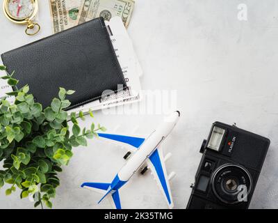 Preparazione del viaggio. Molti oggetti - un aereo giocattolo, una macchina fotografica, denaro, biglietti, documenti su sfondo bianco. Vacanza, lavoro, turismo, divertimento avventura. Là Foto Stock