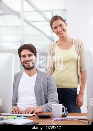 Che duo dinamico. Due giovani colleghi sorridono alla telecamera. Foto Stock