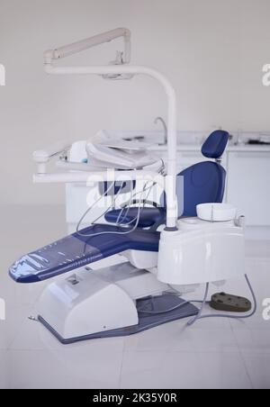 La temuta sedia dentisti. Una foto di una sedia dentale e di altre attrezzature in un dentista ufficio. Foto Stock