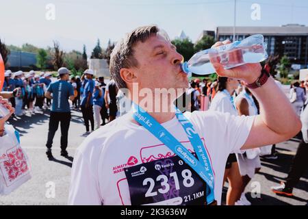 Kazakistan, Almaty-25 settembre 2022: Maratona di Almaty. Uomo bere acqua dopo la fine. Foto Stock