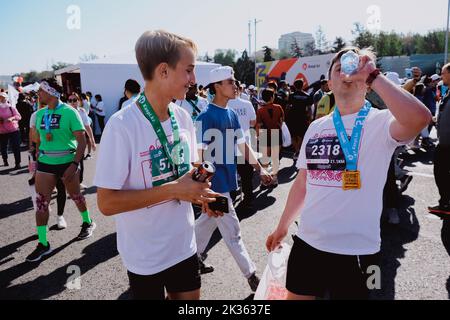 Kazakistan, Almaty-25 settembre 2022: Maratona di Almaty. Uomo bere acqua dopo la fine. Foto Stock