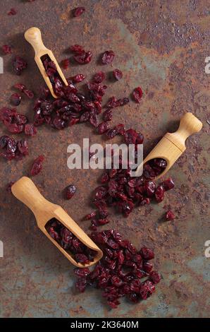 Tre sessole in legno con mirtilli rossi secchi su sfondo mentale di ferro, vista dall'alto Foto Stock