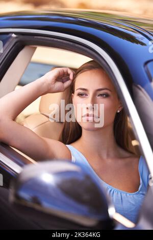 Im a casa dietro il volante. Una donna seduta in un'auto di lusso. Foto Stock